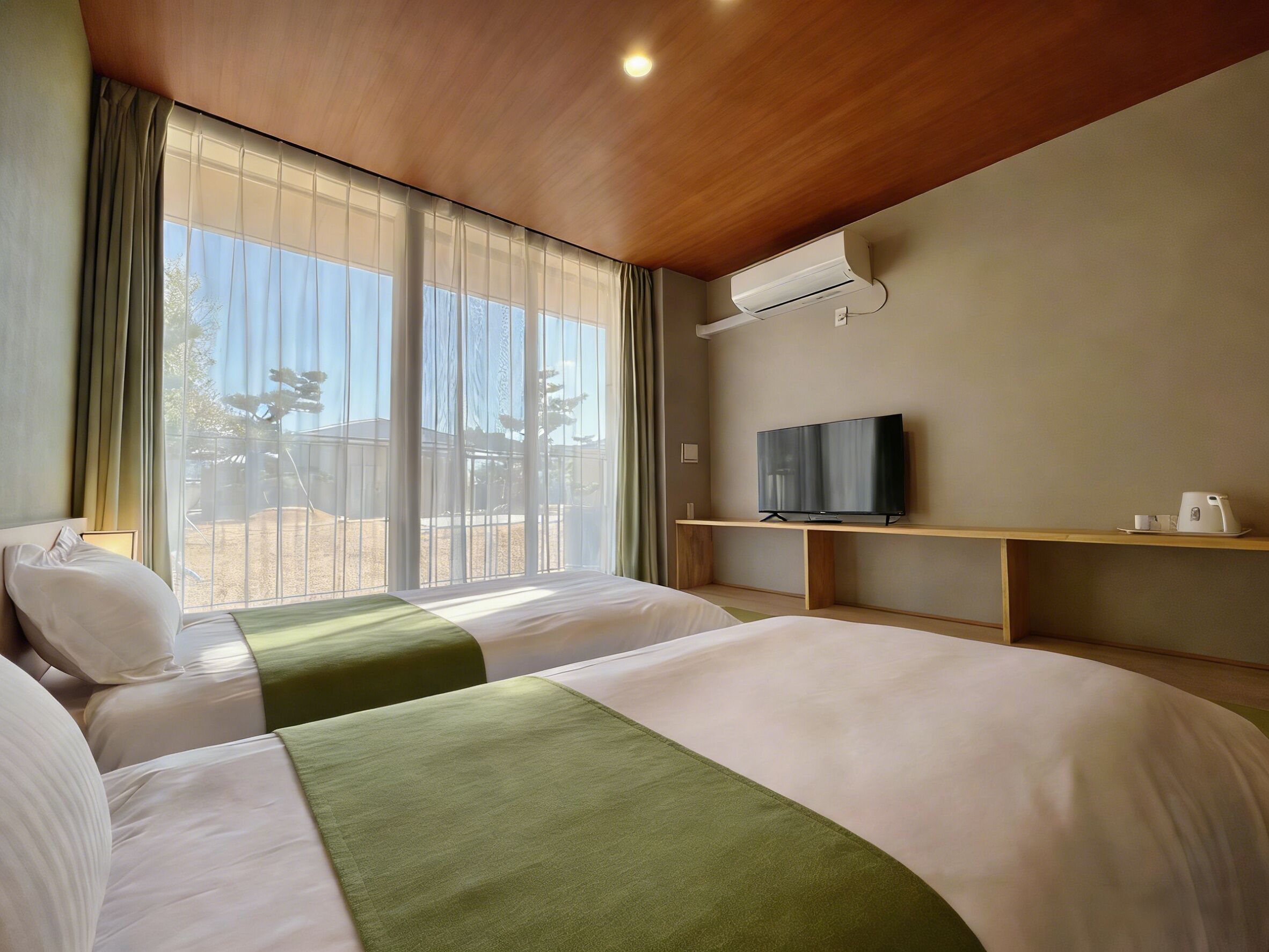 A hotel room with two beds, a TV, a coffee maker, and a large window with curtains.