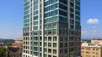 A multi-story hotel with a modern design, featuring a prominent entrance and a rooftop terrace.