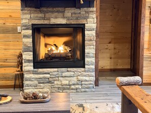 A stone fireplace with a fire, a wooden bench, and a rustic decor.