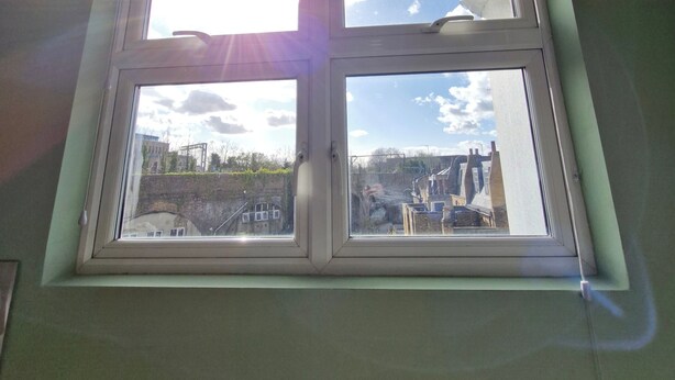 Ein Fenster mit Blick auf Gebäude und einen klaren Himmel.