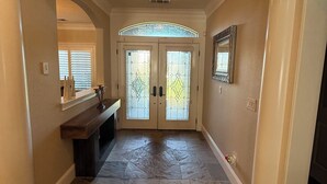 A hallway with a stone floor, a bench, a door with glass panels, and a light fixture. - Home With A View, Beautiful 3 Bedroom 4 Bath, Each Bedroom with Private Bath (Redding)