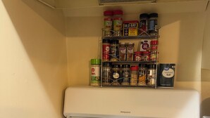 Une cuisine équipée d’une cuisinière, d’une poêle et d’un porte-épices.