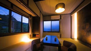 A traditional Japanese room with tatami flooring, a low table, and cushions.