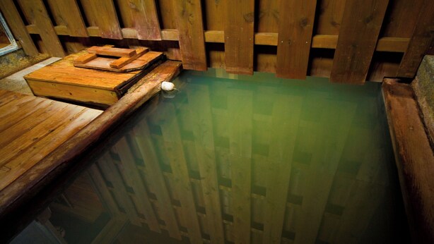 A wooden hot tub with a wooden deck and steps leading into it. - Yamadaya (Beppu)