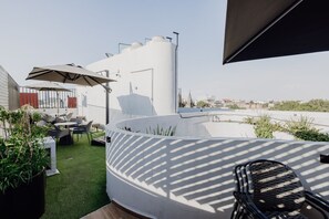 A rooftop terrace with outdoor seating, a water tank, and a view of the cityscape. - Roma Norte 2BR with Panoramic Rooftop and Security (Ciudad de México)