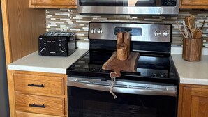 A kitchen with wooden cabinets, a stainless steel microwave, a black stove, and a built-in oven. - 2-bedroom duplex in Mt. Washington on quiet family street near Grandview Ave. (Pittsburgh)