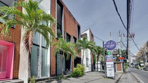 A modern building with a brick facade, large windows, and a sign for 'easy day laundry.' - Rhys Apartment - Berawa (Canggu)