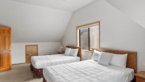 A bedroom with two beds, a wooden wardrobe, a window, and a ceiling light. - 3BR Home steps from Lakeside Beach and Casinos (South Lake Tahoe)
