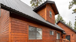 A wooden cabin with a deck, stone pathway, and a small outdoor table and chairs. - 3BR Home steps from Lakeside Beach and Casinos (South Lake Tahoe)