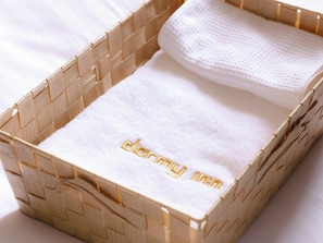 A woven basket containing a white towel with embroidered text.