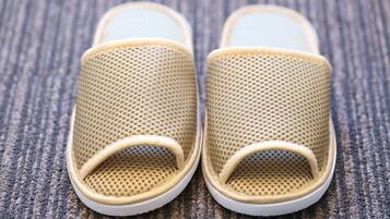 Un par de zapatillas de malla color beige con suela blanca.