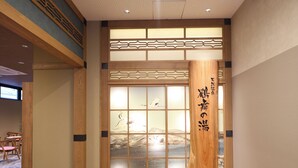 Ein traditioneller japanischer Raum mit Tatami-Boden, einer Shoji-Schiebetür und einer Holzsäule mit Kalligraphie.
