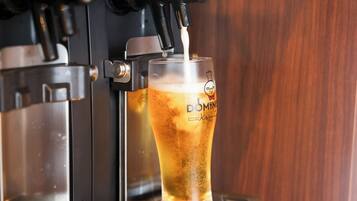 A glass of beer being filled by a tap.