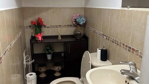 Un bany amb vàter, rentapel i objectes decoratius.