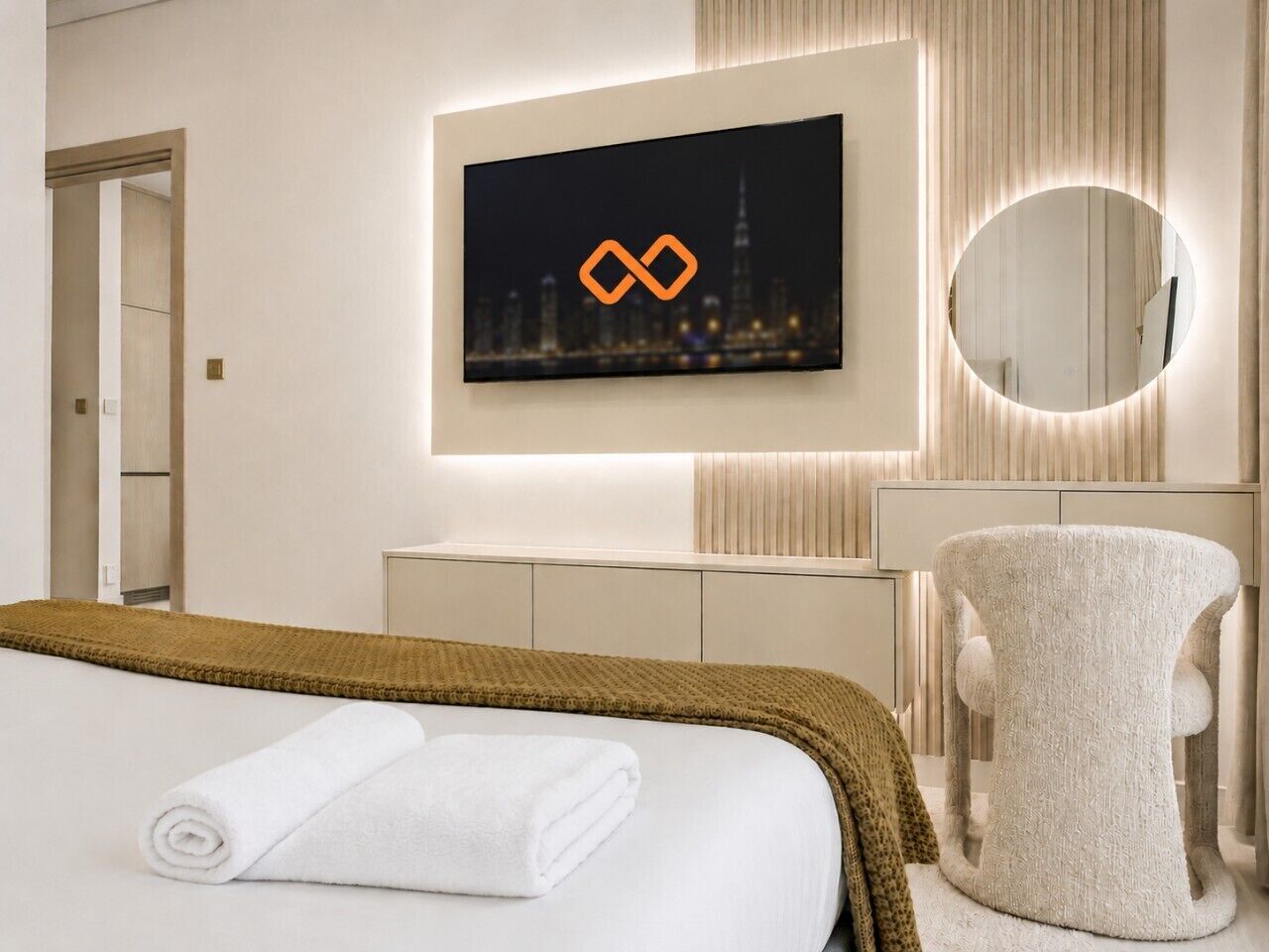 Een hotelkamer met een bed, een aan de muur bevestigde televisie, een ronde spiegel en een stoel.