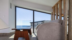 Ett modernt vardagsrum med en stor skjutdörr i glas, ett träbord och en beige soffa.