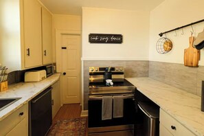 A compact kitchen with a built-in oven, a microwave, and a toaster. - Boutique Cleveland Vibe - Neon Moss Wall - King Bed - Queen Bed (Lakewood)