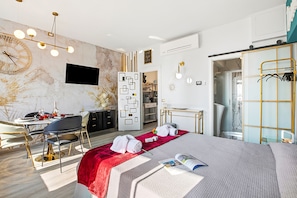 Ein modernes Hotelzimmer mit Bett, Schreibtisch und Sitzecke.
