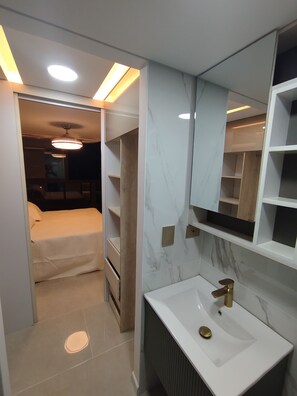 A modern bathroom with a white sink, gold faucet, and marble backsplash. - Loft Deluxe 12th Floor Cali Velodrome View (Cali)