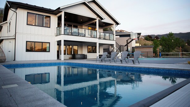 A modern two-story house with a swimming pool, outdoor seating, and a view of the hills. - Poolside retreat with private basketball court (Vernon)