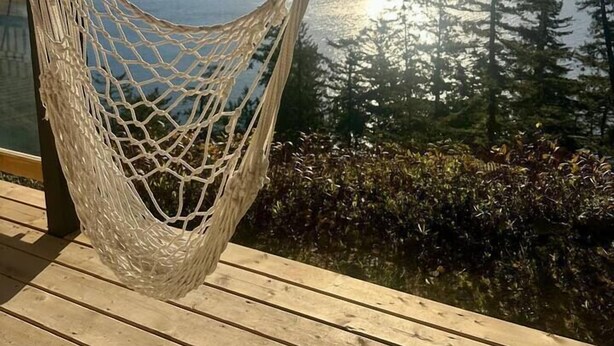 A hammock on a wooden deck with a view of a lake and mountains. - Gorgeous Ocean & Mountain View King Suite (Bowen Island)