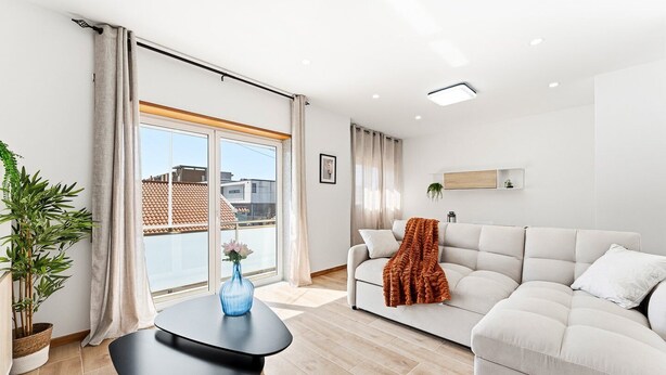 A modern living room with a sofa, a small table, and a potted plant. - GuestReady - Apartment near beach retreat (Vila do Conde)