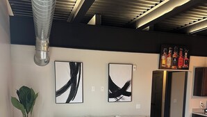 Un salon moderne avec un canapé d’angle, des œuvres d’art abstraites accrochées au mur, une plante en pot et une table basse.