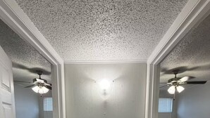 A room with a door, two beds, ceiling fans, and a window. - Radiant 2x1 apt by West Campus UT! (Austin)