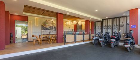 A modern interior with a reception desk, seating area, and motorcycles.