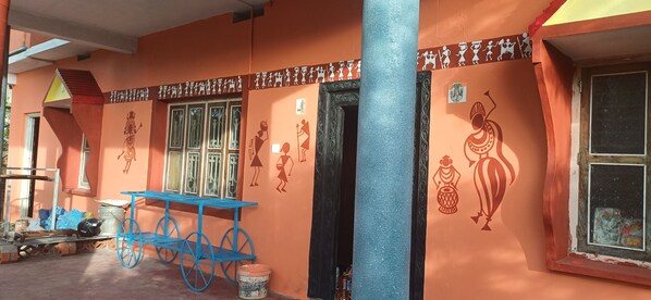 A building with orange walls, a blue cart, and decorative wall art.