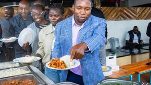 A buffet setup with food items and people serving themselves. - The Cambrian Village Hotel and Resort (Nyamira)