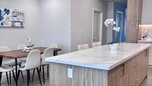 Eine moderne Küche mit einer zentralen Kochinsel, Holzschränken und einer Pendelleuchte.
