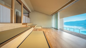 A modern interior with a wooden floor, a tatami mat, and a view of a body of water. - Hoshino Resorts KAI Miyajima (Hatsukaichi)