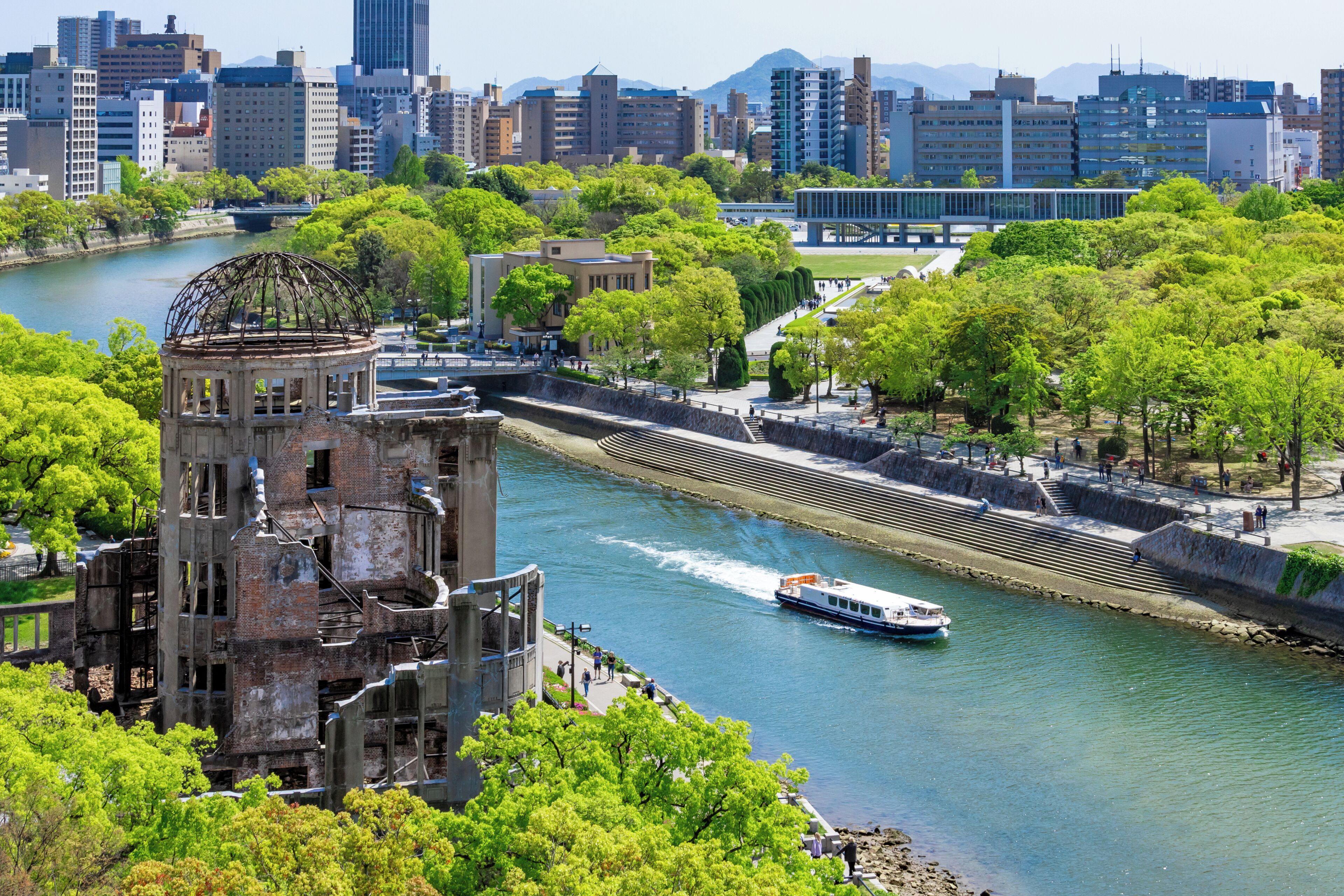 Un río con una barca, rodeado de árboles y edificios.