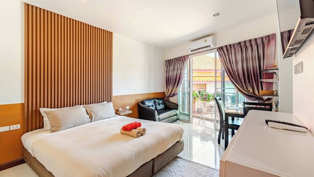 Habitación de hotel con cama, escritorio, silla y vistas al exterior.