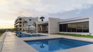 Um hotel moderno com piscina, área de estar externa e vista para a paisagem.