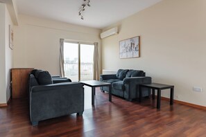 Ein modernes Wohnzimmer mit einer Sofagarnitur, einem Couchtisch und einem Bild an der Wand.