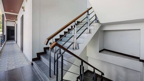 Ein modernes Interieur mit Treppe, Flur und Tür am Ende.