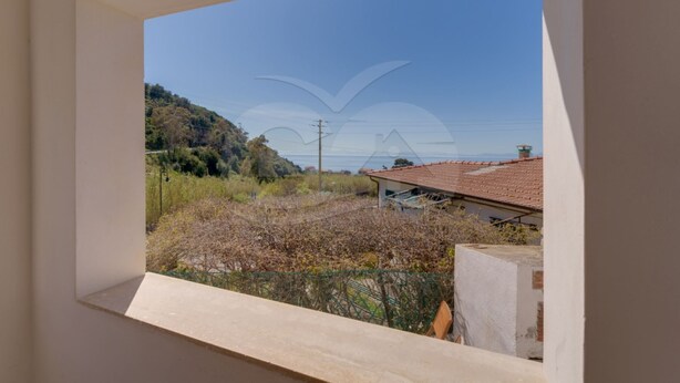 A window view of a building with a tiled roof, surrounded by vegetation and a hilly landscape. - Sunset Goelba - where the rock meets the sea (Marciana)