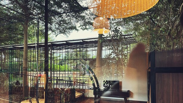 A room with a large window, a wooden floor, and a chair. - An Nhiên Farm dormitory with bunk beds (Pleiku)
