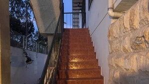 A staircase with stone walls and metal railings, leading to an upper level.