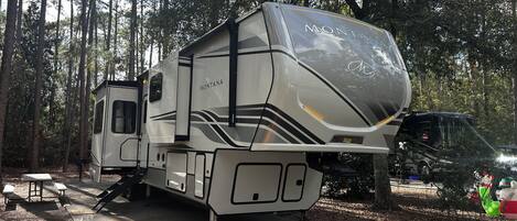 A motorhome with a 'MONTANA' logo, a covered rear section, and a side entrance.