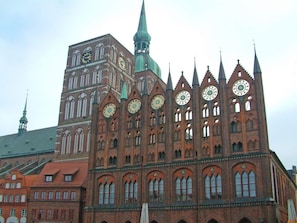 Ein großes Backsteingebäude mit zahlreichen Türmen und Uhrengesichtern.