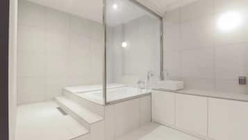 Un baño moderno con ducha de vidrio, una bañera independiente y un tocador con lavabo.