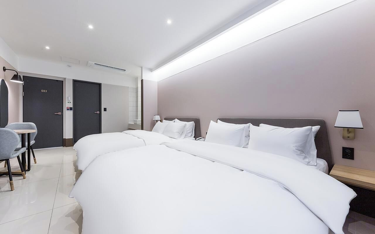 Una habitación de hotel con dos camas, un escritorio y una silla.