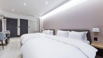 Una habitación de hotel con dos camas, un escritorio y una silla.