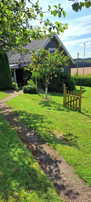 A house with a fenced yard, a pathway, and a small tree. - Welcome to Lillstugan (Jämshög)