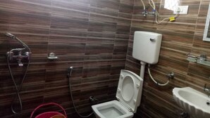Un baño con inodoro, bidé y lavamanos.