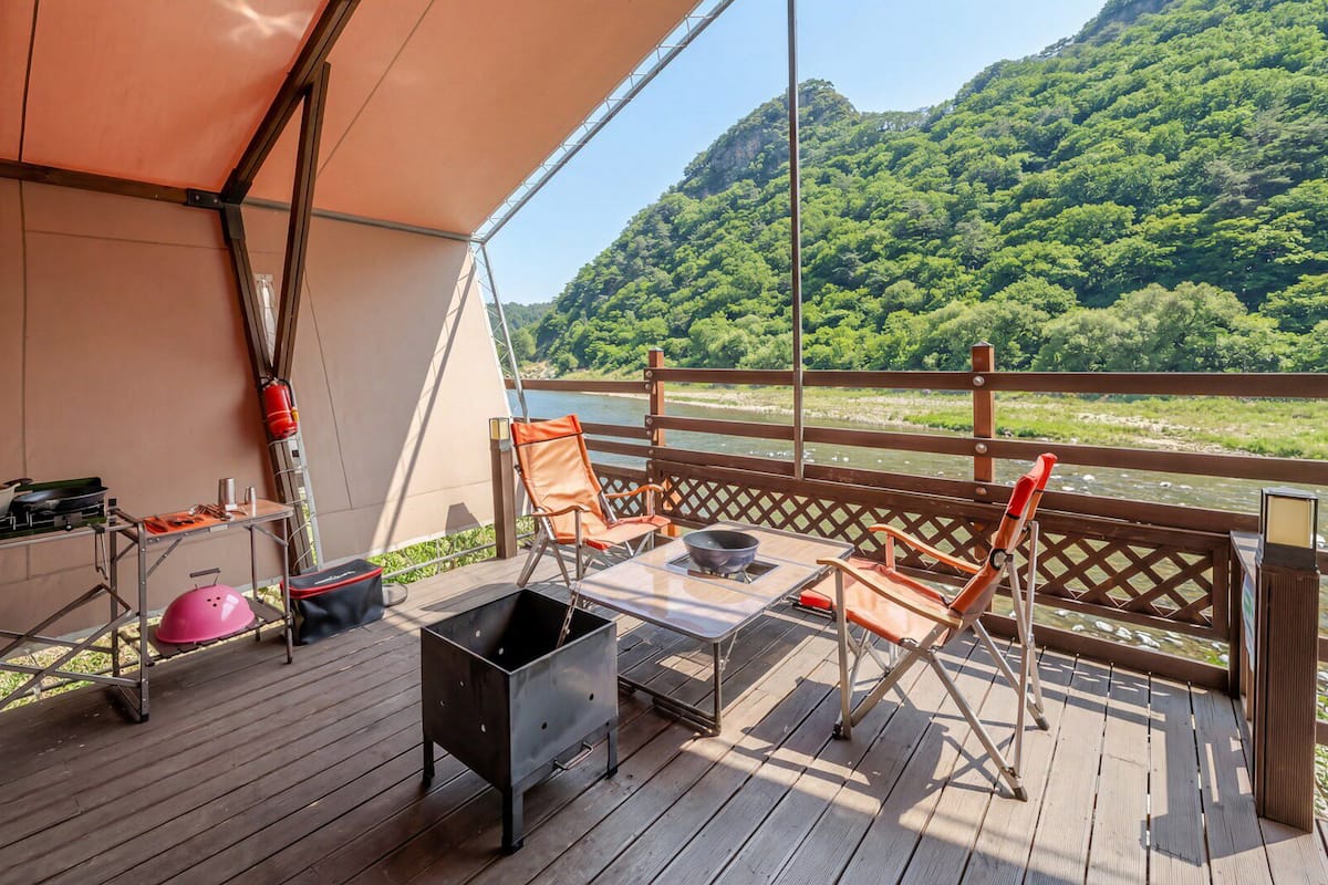 A deck with outdoor furniture, a grill, and a helmet.