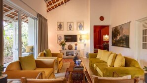 A living room with sofas, a coffee table, and a TV. There are framed pictures on the wall and a painting above the sofa. - Heuvel Villa Kandy (Kandy)